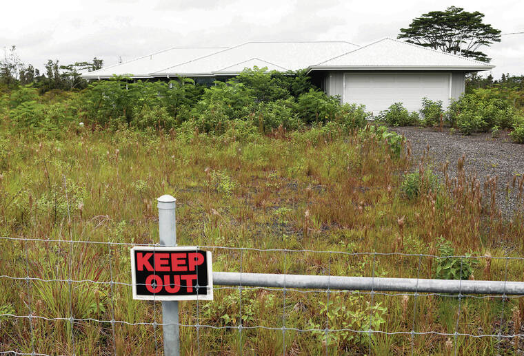 TRIBUNE-HERALD / JUNE 7
                                Grass and brush are overgrown around a house that was mistakenly built on the wrong lot in Hawaiian Paradise Park.